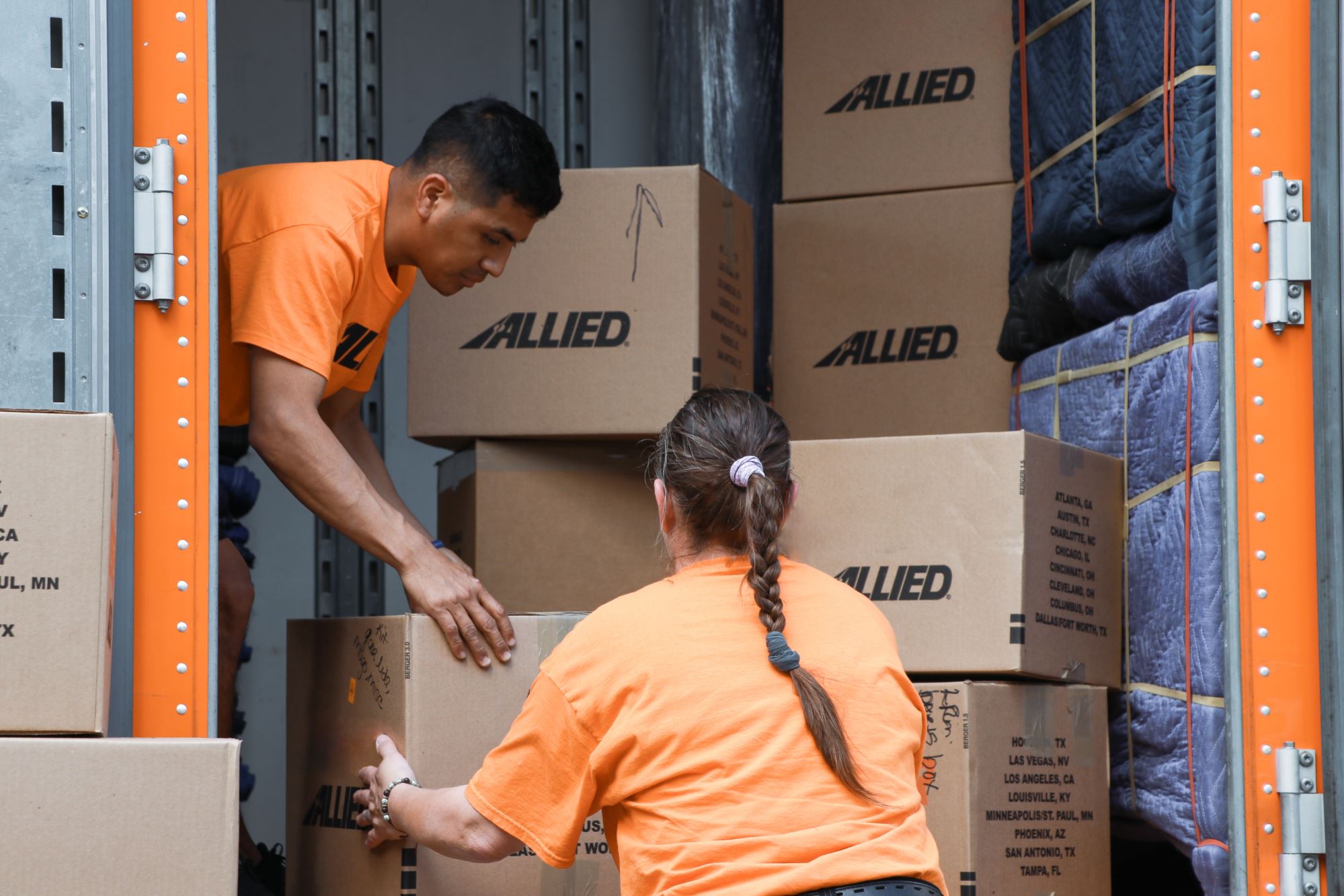 Allied movers stacking boxes in truck